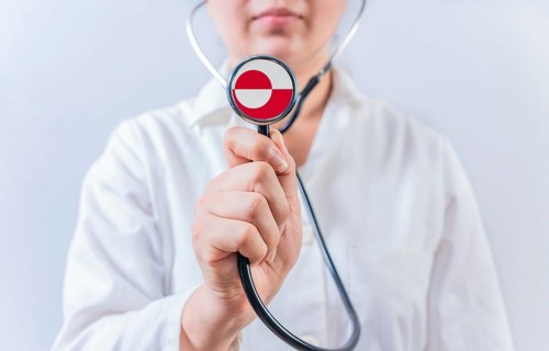 Female doctor holding stethoscope with Greenland flag. National Health System of Greenland