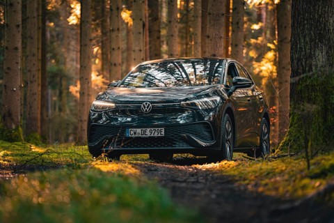 Black car on a forest path, surrounded by dense trees, car sharing vehicle Deer Mobility, electric