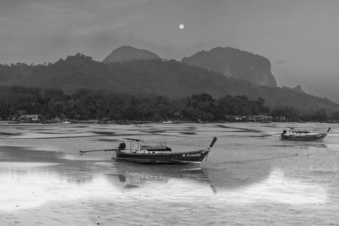 Before sunrise, longtail boats lie at low tide in the harbour at Sivalai Beach, Koh Mook Island,