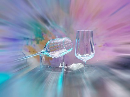 Light art, various glasses on silver foil, behind them various splashes of colour, zoom effect,