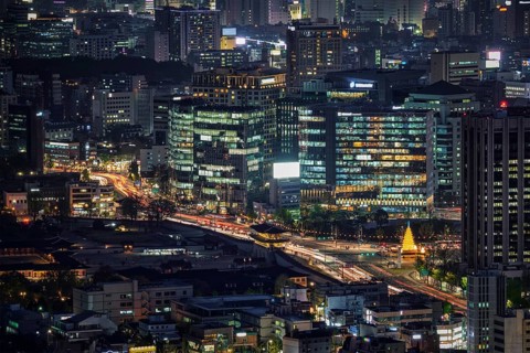 Seoul skyscrapers and Gyeongbokgung palace illuminated with lights view from Inwang mountain.