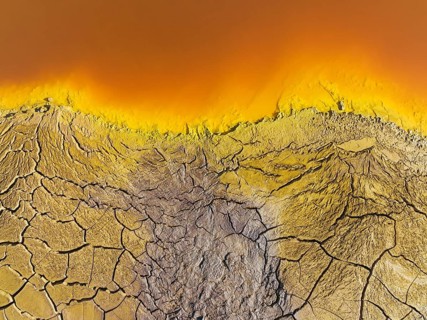 Cracked earth at the bank of the Rio Tinto (Red river) with its deep reddish hue due to oxidised
