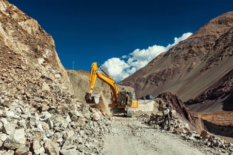 LADAKH, INDIA, SEPTEMBER 10, 2011: Excavator cleaning road after landslide in Himalayas. Ladakh,