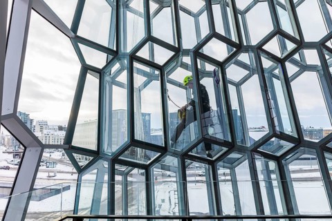 Window cleaners cleaning the glass facade of the Harpa Concert Hall and Congress Centre, interior