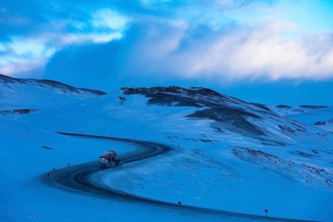 Snow removal vehicle on ice on Ring Road No. 1, snow-covered geothermal area, North Iceland