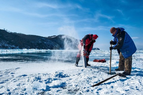 Digging a hole in the ice for scuba diving, Lake Baikal, Olkhon Island, Pribaikalsky National Park,