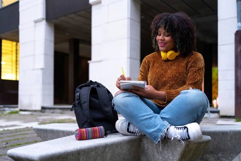 Portrait of black ethnic girl sitting in college doing classwork or studying for an exam