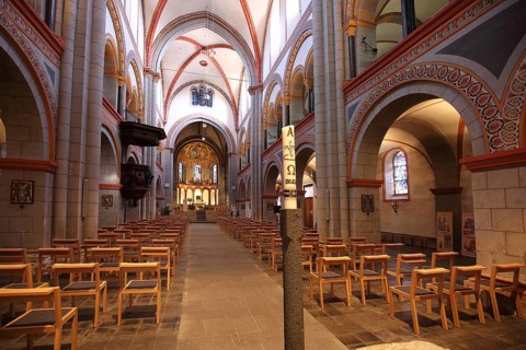 Interior view of the late Romanesque Church of the Assumption of Mary with pulpit and candle,