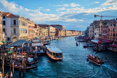 VENICE, ITALY, JUNE 27, 2018: Grand Canal with boats, vaporetto and gondolas on sunset from Rialto