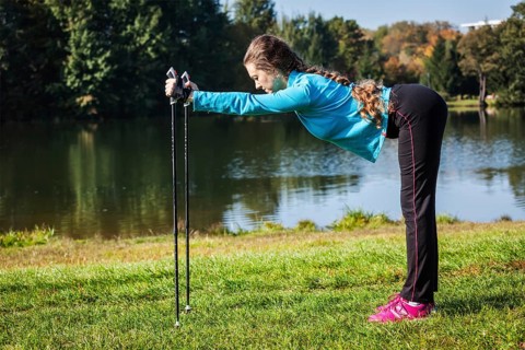 Nordic walking adventure and exercising concept, woman doing exercise with nordic walking poles in