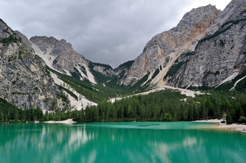 Turquoise water of the Lake Prags Lake, surrounded by pine forest and mountains in the Lake Prags