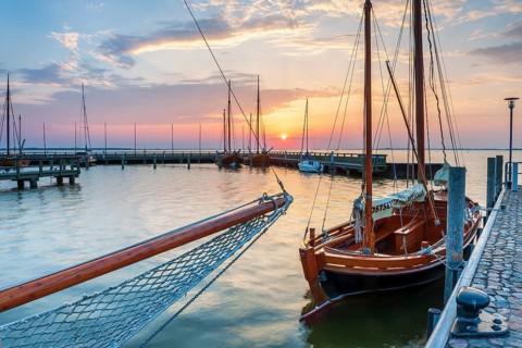 Sailboats and Zeesenboats in the harbour of Dierhagen on the Saaler Bodden at sunrise,