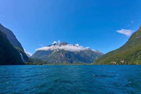 Majestic mountain landscape with clear fjord and light clouds under a sunny sky, summer, Milford