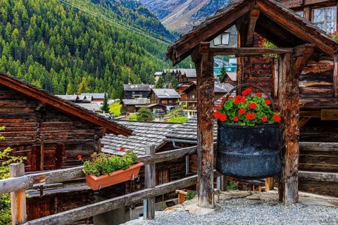 Old copper kettle decorated with flowers in the historic village centre, Grimentz, Val d'Anniviers,