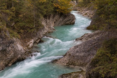 Rissbach creek flowing fast through the Riss valley. Autumn colors around