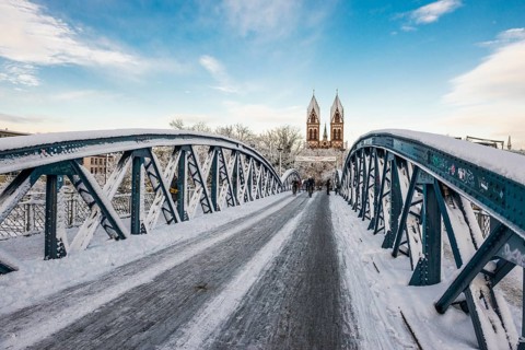 Bridge with snow and ice and cyclists, Blue Bridge and Stühlinger Church, Freiburg im Breisgau,