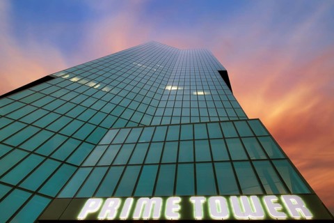 Modern high-rise building Prime Tower with glass facade, coloured clouds in the evening sky after