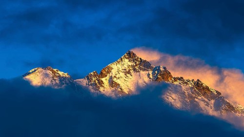 Snow-covered summit of the Weisshorn mountain, illuminated by the evening sun, view from Grimentz,