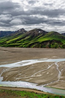 River in large riverbed, Moss-covered mountains, Rhyolite mountains, Volcanic landscape,