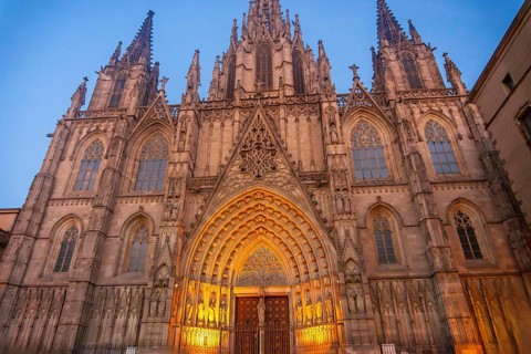 Warm lights illuminating the ornate facade of barcelona cathedral in the gothic quarter at dusk,