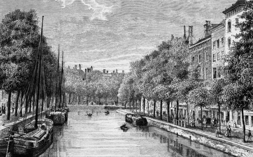 Tree-lined canal in the Dutch capital Amsterdam, cargo ships, promenade with pedestrians,