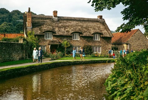 Touristen spazieren am attraktiven reetgedeckten Beck Isle Cottage, Thornton Beck stream, Thornton