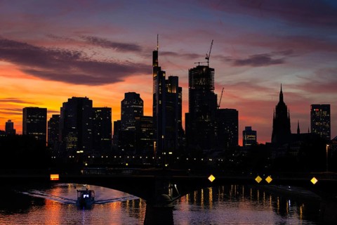 The silhouette of Frankfurt's banking skyline stands out against the luminous evening sky in the