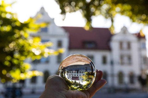 Hand with glass ball in which the Zentralgasthof refracts, Weinböhla, Saxony, Germany, Europe