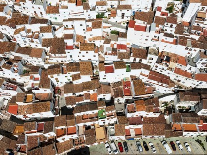 The brilliant White Town of Casares clings to a steep hillside. Aerial view. Drone shot. Málaga
