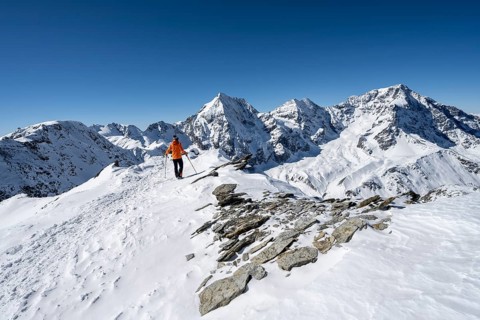Ski tourers on foot, mountain panorama with snow-covered mountain landscape in winter, view of