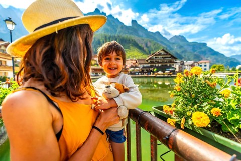 Tourists enjoying summer holidays in the picturesque village of alleghe, surrounded by the stunning