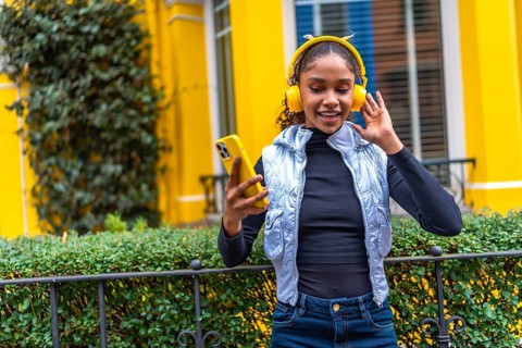 Frontal portrait of a cool urban african american urban woman dancing listening to music in the