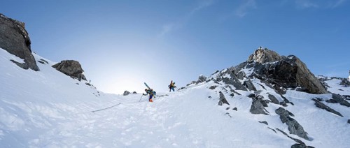 Mountaineer with skis descending through a steep snowfield on the Porta d'Es-cha, in winter, alpine