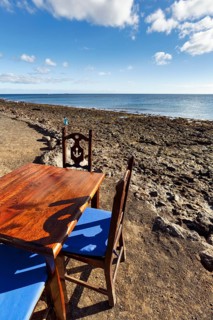 Wooden table and chairs, fish restaurant on the beach, Playa Quemada, Yaiza, Lanzarote, Spain,