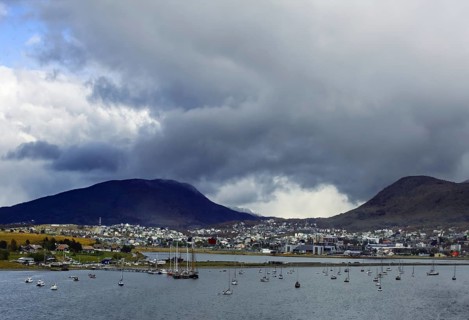View of Ushuaia with sailing boats in front of cloudy mountains and cloudy sky, Ushuaia, Argentina,