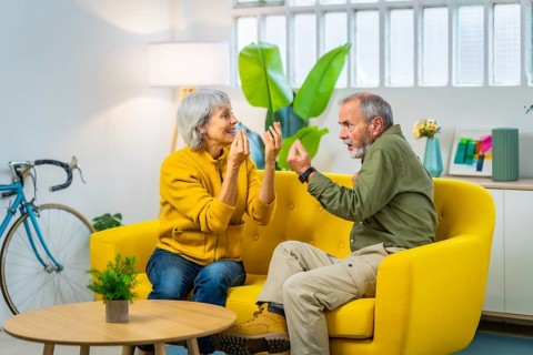 Full length photo of a caucasian senior couple arguing and discussing sitting on the sofa
