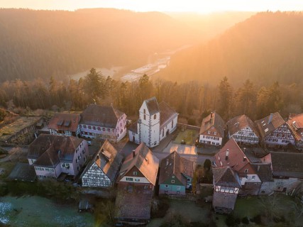 Small village with church and half-timbered houses in a hilly landscape at sunrise, Zavelstein,