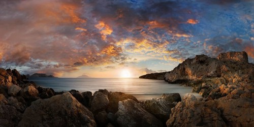 Dramatic sunset at the fishing village of Finiki by the sea with rocky coastline, Finiki,