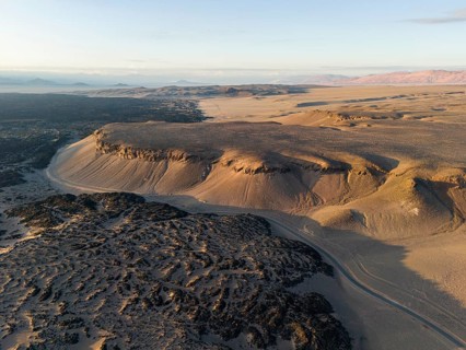 Aerial view of a vast desert landscape with bare rocks and a distant horizon, Argentina, volcanoes,