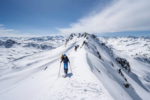 Ski tourer on a mountain ridge, mountain landscape with snow, mountain panorama with summit of the