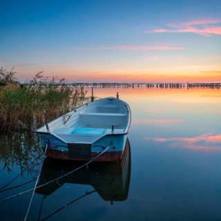 Sunset, rowing boat moored in the reeds, Großer Jasmunder Bodden, Rügen Island, Mecklenburg-Western