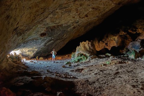 Woman in the darkness of the vast Limniatis Cave, Hike from Aperi to Limniatis Cave, Limniatis