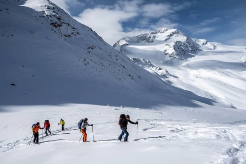 Ski tourers, behind the summit of Monte Cevedale, snow-covered mountain landscape, Ortler Alps,