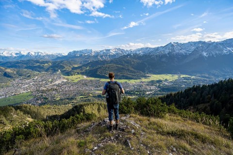 View of Garmisch-Partenkirchen and mountain panorama, mountaineer on hiking trail to Kramerspitz,
