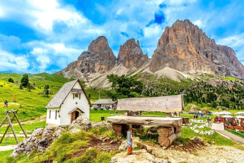 Breathtaking summer view of the majestic sassolungo mountain at sella pass, featuring a wooden
