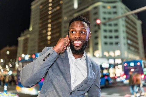Young businessman engaging in a phone conversation while navigating the bustling city center at