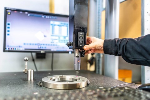 Man working with three-dimensional verification and measuring machine in a cnc innovative factory