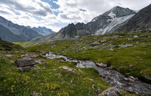 Mountain stream, mountain landscape with mountain peak Pigne d'Arolla and glacier Glacier de