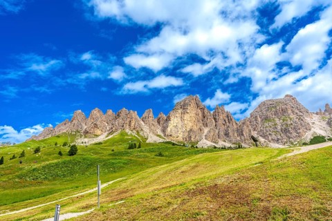 Green meadows and imposing peaks of the dolomites illuminated by the summer sun, creating a