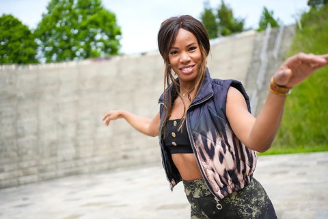 Happy beauty latin woman dancing alone in a park